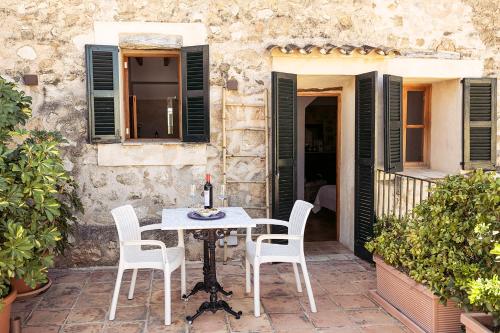 a table and chairs on the patio of a house at Hotel Nord Boutique in Estellencs