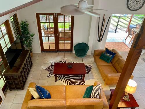 a living room with a couch and a table at Villa Coral - Tropical Oasis Footsteps to Four Mile Beach in Port Douglas