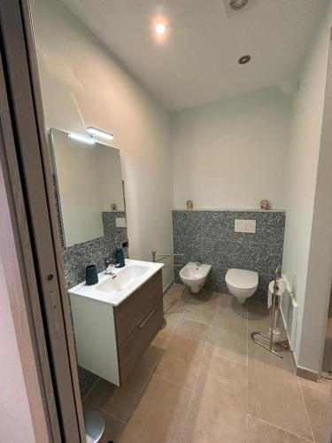 a bathroom with a sink and a toilet and a mirror at Le stanze di Efesto in Linguaglossa