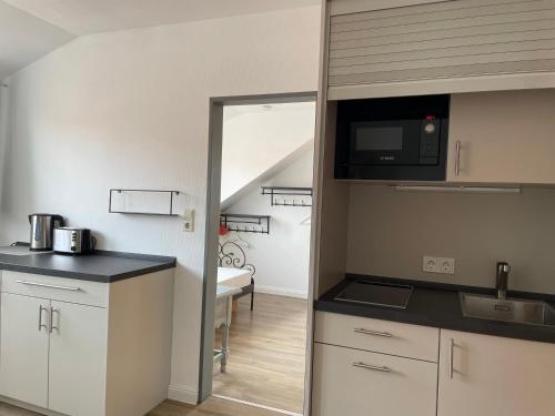 eine Küche mit einer Spüle und einer Mikrowelle in der Unterkunft Aparthotel Domizil in Borkum