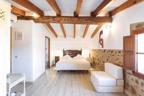 a bedroom with a bed and a couch in a room at Hotel Nord Boutique in Estellencs