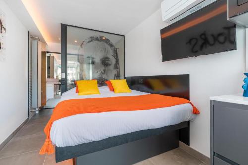 une chambre avec un grand lit avec des oreillers jaunes dans l'établissement Village Naturiste R4N - Le Xillion Port Nature, au Cap d'Agde