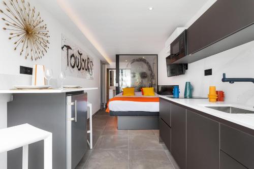 - une cuisine avec un lit au milieu d'une pièce dans l'établissement Village Naturiste R4N - Le Xillion Port Nature, au Cap d'Agde