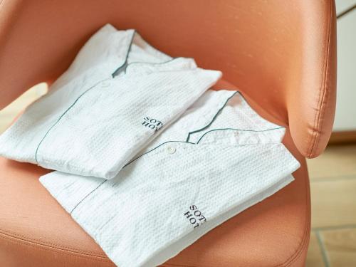 a pile of white towels sitting on a orange chair at SOTETSU GRAND FRESA TAKADANOBABA in Tokyo