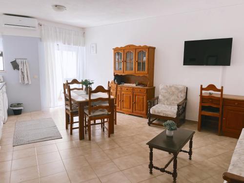 a living room with a table and chairs and a tv at Mira Sol - Silhueta Citadina in Portimão
