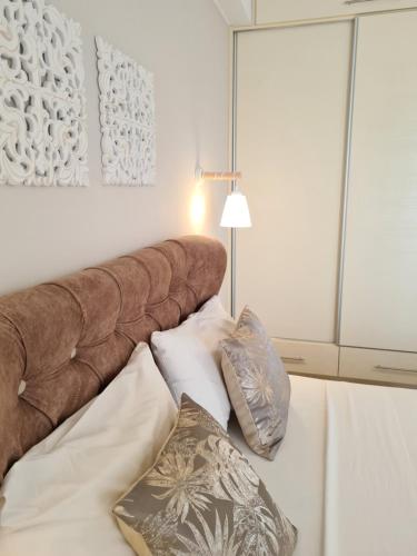 a brown headboard of a bed with two pillows at Bella Mare Luxury Apartments in Kalamaki