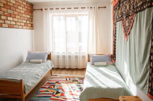 a room with two beds and a window at Guest House Altyn Oimok in Bokonbayevo