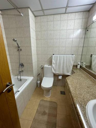 ein Badezimmer mit einem WC, einer Badewanne und einem Waschbecken in der Unterkunft Cosy home near metro station in Dubai