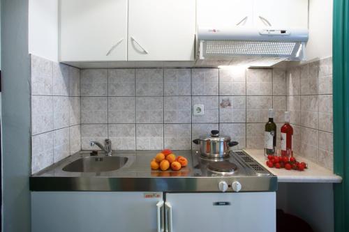 eine Küche mit einer Spüle und einer Theke mit Obst darauf in der Unterkunft Sofia Studios Kathisma in Kalamitsi