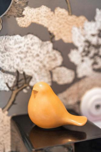 a yellow bird figurine sitting on top of a table at Garlande Hôtel Avignon Centre in Avignon