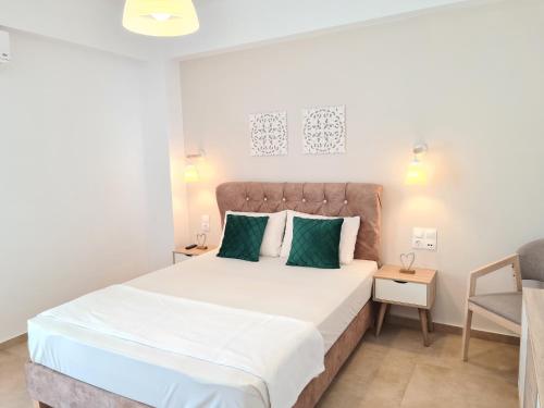 a bedroom with a large bed and a chair at Bella Mare Luxury Apartments in Kalamaki Heraklion