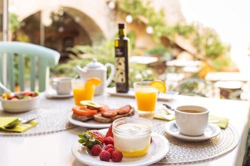 a table topped with plates of food and drinks at Hotel Nord Boutique in Estellencs