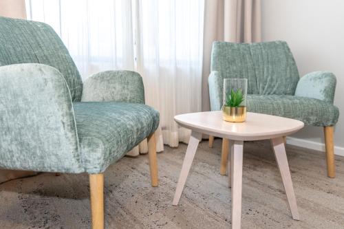 a living room with two chairs and a table at Waastwinj - 500m vom Strand in Utersum