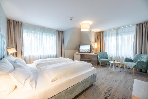 ein Hotelzimmer mit 2 Betten und einem TV in der Unterkunft Waastwinj - 500m vom Strand in Utersum