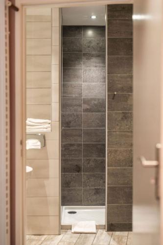 a shower with a glass door in a bathroom at Garlande Hôtel Avignon Centre in Avignon
