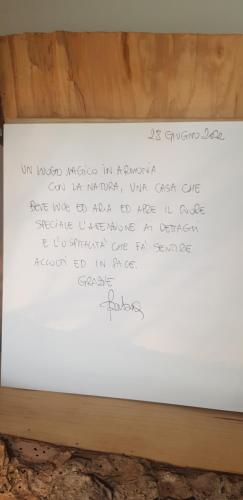 un morceau de papier à écrire sur un tableau blanc dans l'établissement Ca' di Rae Bed&Breakfast olistico, à Almenno San Bartolomeo