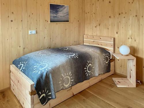 a bedroom with a bed in a wooden room at Ferienhaus LebenPUR Bio-Ferienhaus aus Holz in Parin
