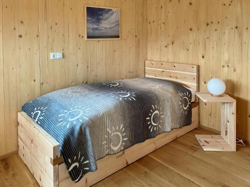 une chambre avec un lit dans une pièce en bois dans l'établissement Ferienhaus LebenPUR Bio-Ferienhaus aus Holz, à Parin