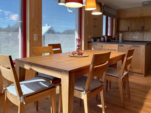 a wooden table and chairs in a kitchen with a window at Ferienhaus LebenPUR Bio-Ferienhaus aus Holz in Parin