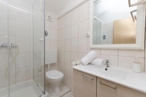 a bathroom with a toilet and a shower and a sink at Apartments Anton in Vodice