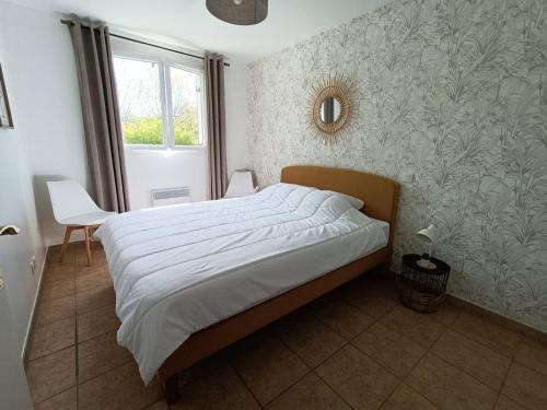 een slaapkamer met een bed, een stoel en een raam bij Appartement Cambo-les-Bains, 2 pièces, 4 personnes - FR-1-495-33 in Cambo-les-Bains