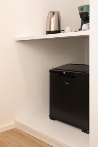 a black appliance sitting on a shelf in a kitchen at Metropolitan Rooms in Cagliari