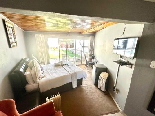a bedroom with a bed and a tv in a room at Horizon Bed and Breakfast in Roodepoort