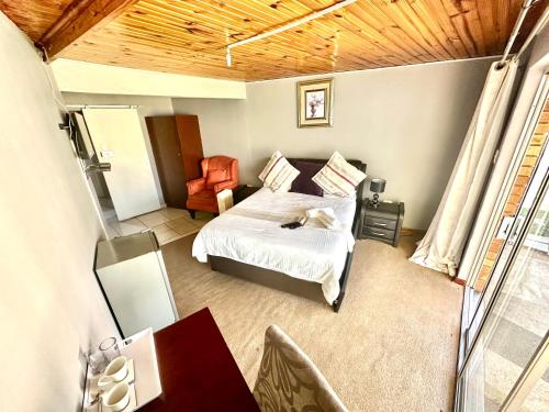 a bedroom with a bed and a desk and a mirror at Horizon Bed and Breakfast in Roodepoort