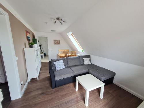 a living room with a couch and a table at Ferienwohnung Leuchtturmkieker in Schlagsdorf auf Fehmarn in Fehmarn