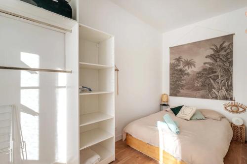 une chambre avec un lit et une étagère dans l'établissement Charmant T2 Proche du Prado, Perier et Castellane, à Marseille
