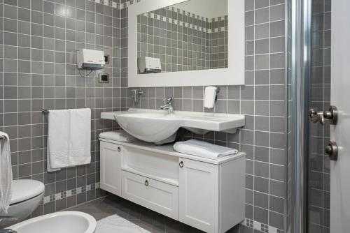a bathroom with a sink and a toilet and a mirror at La Canonica Suite Apartments New Location in Trento