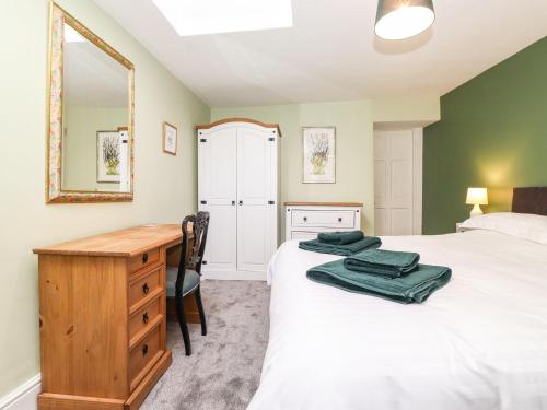 una camera con letto, scrivania e specchio di West Farm Cottage a Morpeth