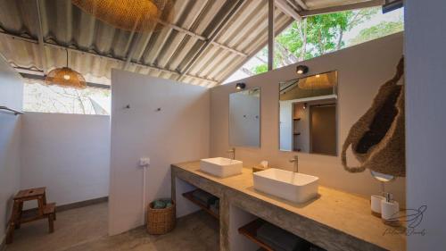 La salle de bains est pourvue de 2 lavabos et d'un grand miroir. dans l'établissement Elephant View Camp, à Ban Huai Thawai