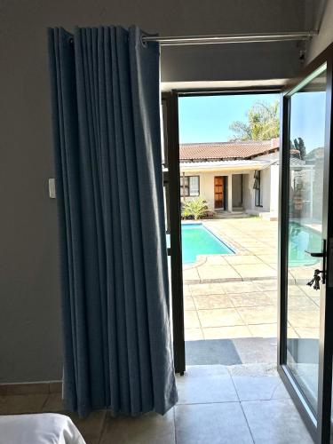 a room with a sliding glass door to a pool at Horizon Bed and Breakfast in Roodepoort