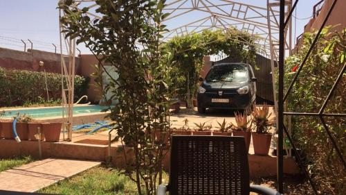 穆罕默迪耶的住宿－Villa à la compagne，停泊在带游泳池的花园中的汽车