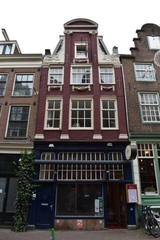 a tall red brick building on a city street at Rembrandtplein Apartments in Amsterdam