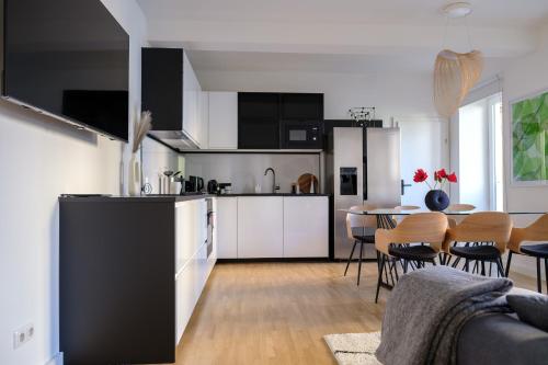 una cocina con armarios blancos y una mesa con sillas. en Vienna Experience, en Viena