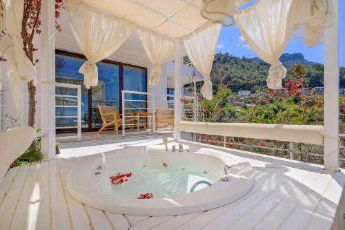 a hot tub on the deck of a house at Highclere Hotel and Spa in Faralya