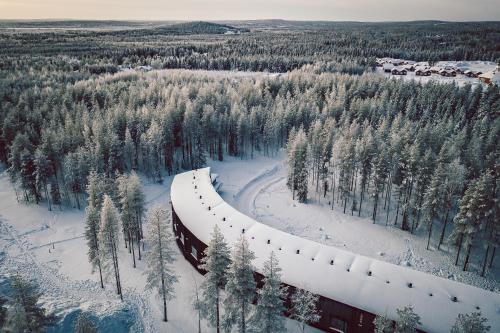 a train is traveling through a snow covered forest at Nova Skyland Hotel in Rovaniemi
