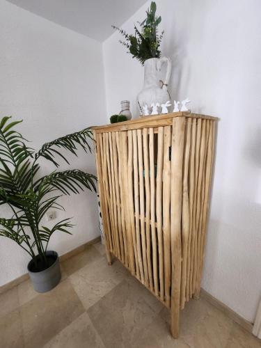 a wooden stand with a vase and plants on it at Casa de Almano - Torremolinos direct on beach in Torremolinos