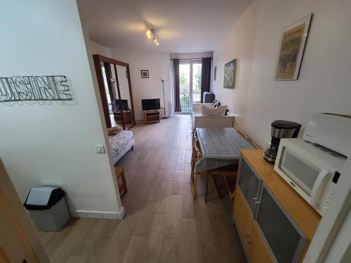 un salon avec une cuisine et un salon avec un four micro-ondes dans l'établissement Appartement Paris Centre - St Michel, à Paris