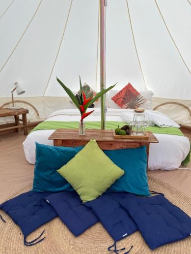 Bett mit blauen und grünen Kissen in einem Zimmer in der Unterkunft Kalika Balayan in Balayan