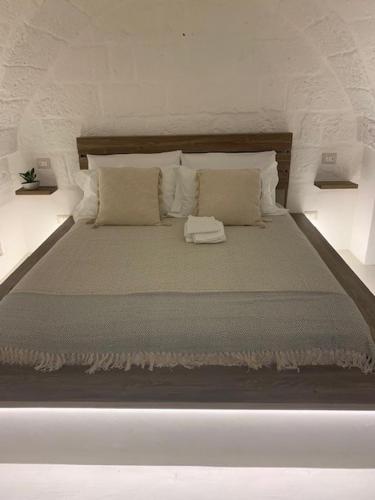 duże białe łóżko z poduszkami w obiekcie Boutique Room One w mieście Fasano