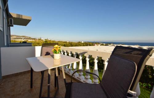 a table and chairs on a balcony with a view of the ocean at KOYNTOYRA ROOMS in Kountoura Selino