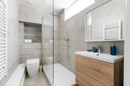 a bathroom with a shower and a toilet and a sink at Fabulous Chelsea 2 bed in London