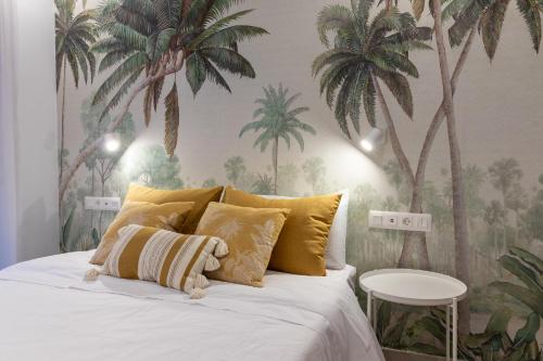 Schlafzimmer mit einem Bett mit Palmen an der Wand in der Unterkunft Viriato - Wifi - AC - Terraza compartida in Guanarteme