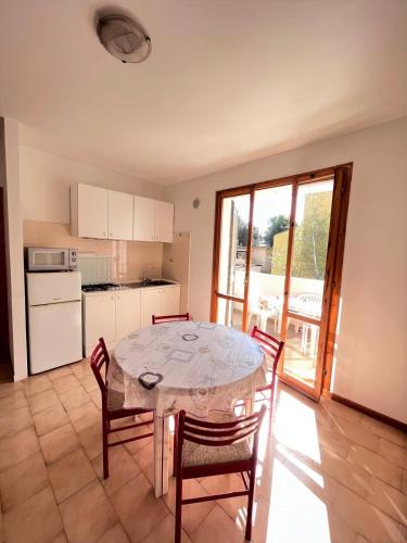 a kitchen with a table and chairs and a kitchen with a window at Bilo Giacomo a 150 m dal mare in Marcelli