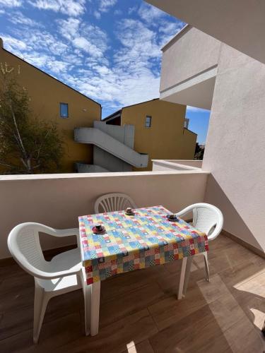 a table and chairs on a balcony with a view of a building at Bilo Giacomo a 150 m dal mare in Marcelli