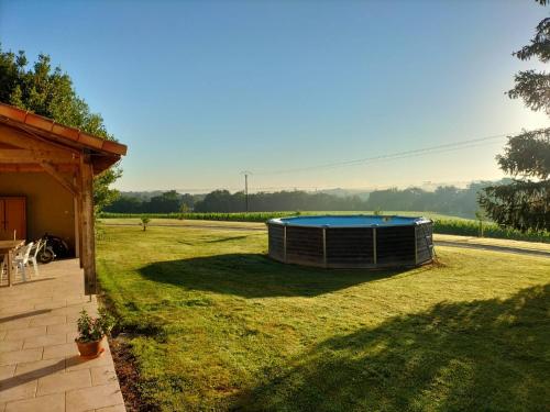 a backyard with a small pool in the grass at le Pigeonnier gersois in Condom