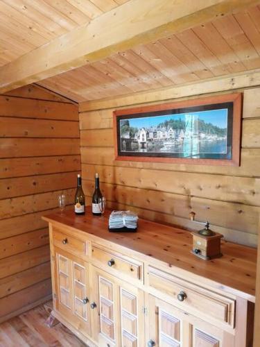 une cabane en bois avec une télévision murale dans l'établissement Chalet en pleine nature au bord d'un étang, à Lanvallay